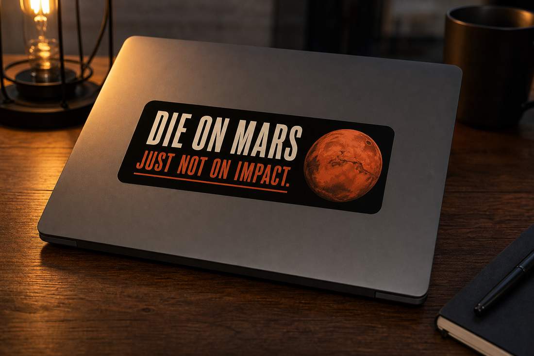 Die on Mars bumper sticker on a closed laptop, warm lamp light.